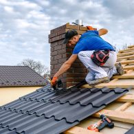a professional master (roofer) with electric screwdriver covers repairs the roof